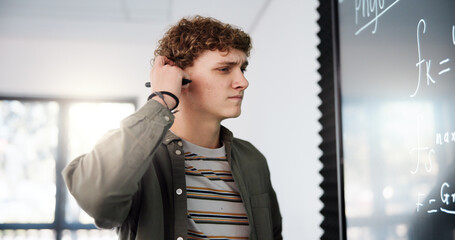 Thinking, confused and math with man in classroom for formula solution, education and problem solving. Science, doubt and equation with person in college for learning, study and physics course