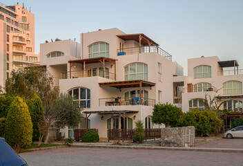 Modern architecture shines under the soft glow of sunset in a coastal community filled with vibrant...