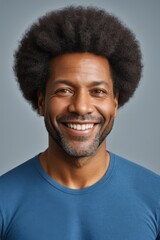 Obraz premium smiling man with afro hair and blue shirt on gray background