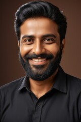 Fototapeta premium smiling man with beard and black shirt posing for a picture