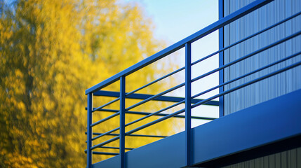 Blue metal railing against autumn trees. Perfect for architectural details, urban design, and safety features.