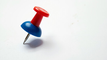 Close-up of a colorful push pin on white background, ideal for office supply ads, educational materials, and organizational tips.