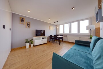 Salon w nowoczesnym apartamencie z ciemnozieloną pluszową sofą © arteffect.pl