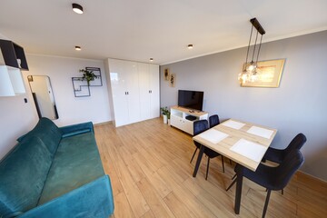 Salon w nowoczesnym apartamencie z ciemnozieloną pluszową sofą © arteffect.pl