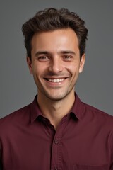 Obraz premium smiling man in maroon shirt with short hair and a smile