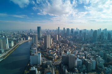 Obraz premium Urban skyline reflecting in calm water during late afternoon with clouds in the sky
