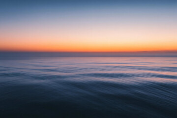 Fototapeta premium Sunset over calm ocean waters creates a serene atmosphere with vibrant colors on the horizon