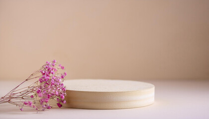 Minimalist round podium in beige tones, dried pink flowers on backdrop. Empty pedestal. Mock-up