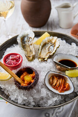 Gourmet Seafood Platter with Oyster, Sea Urchin, and Anadara on Ice - Vibrant Colors and Contrasting Textures Highlighted in Natural Light