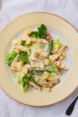 Elegant Caesar Salad with Grilled Chicken Fillet on Textured White Background