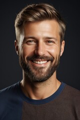 Obraz premium smiling man with beard and mustache in front of black background