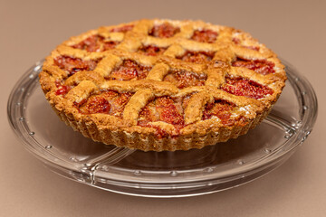 Rustic Italian fig tart featuring a lattice design and juicy fruit filling, made with love and tradition, displayed on a transparent plate