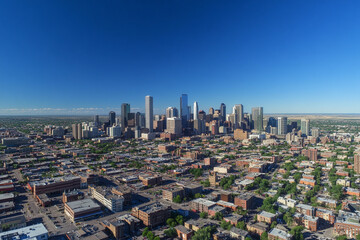 Fototapeta premium Urban skyline reflecting in calm water during late afternoon with clouds in the sky
