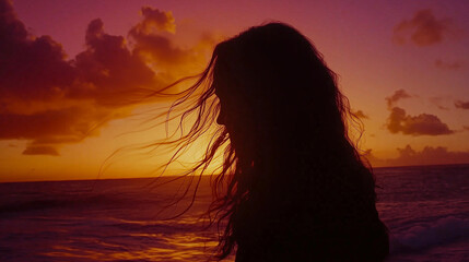 A poetic silhouette of a woman standing by the ocean at sunset, her hair flowing in the wind. A dreamy and introspective image symbolizing solitude, beauty, and emotional reflection.