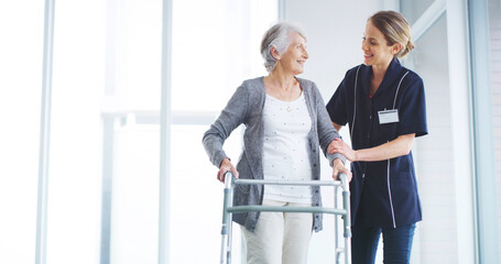 Clinic, caregiver and balance for woman with disability, kindness or smile for support for physical therapy. Healthcare, patient and senior person with walker in nursing home, space or rehabilitation
