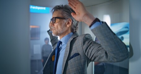 International Airport Terminal: Mature Businessman Walks in Metal Detector on Security Checkpoint...