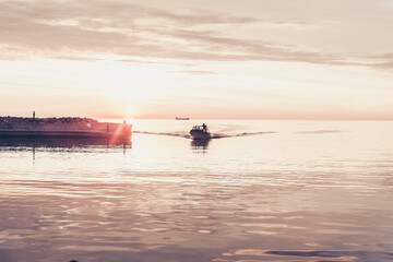boat coming into pier in the sunset