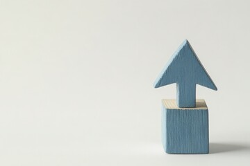 A person places a blue arrow on a stack of wooden blocks