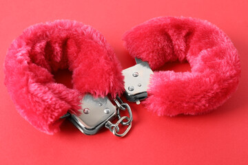 Pink fluffy handcuffs on color background, closeup. Sex toy