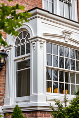 Fototapeta premium Elegant Victorian Bay Window: Architectural Detail and Design in a Classic Brick Home