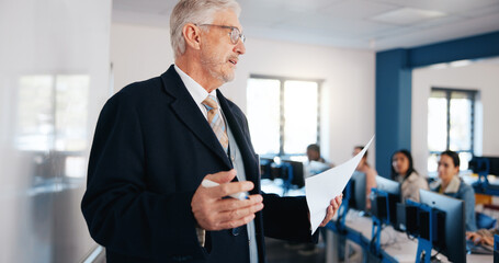 Mature man, lecturer and lesson with whiteboard in classroom for presentation, teaching or learning. Male person, professor or teacher with curriculum or students for higher education or IT course