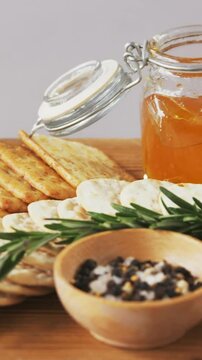 Bowl of green olives, spices, crispy biscuits, jam, rosemary herb, cheese and walnuts