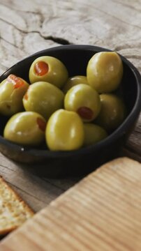 Crispy biscuits, knife, olives, jam, rosemary herb and walnuts