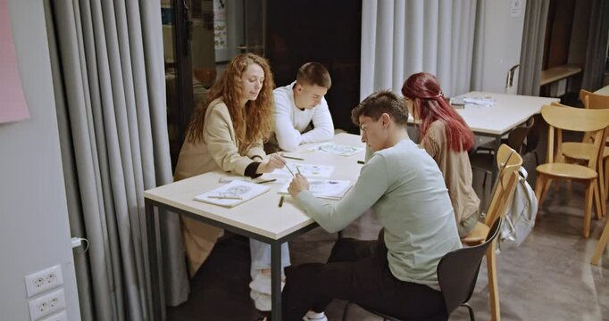 Students work together on an art project after class, drawing and painting in a modern classroom, demonstrating creativity and strong teamwork in a collaborative learning environment.