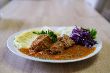 Hearty stew with mashed potatoes and red cabbage