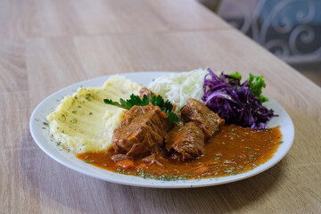 Hearty stew with mashed potatoes and a side salad