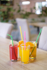 Refreshing summer drinks with citrus fruits served in glasses with straws