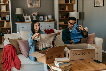 Happy couple checking their outfits and tidying up in a bright living room