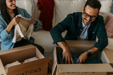 Happy couple checking their outfits and tidying up in a bright living room