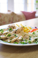Creamy mushroom chicken with fries and salad
