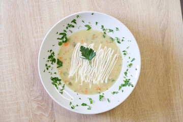 Creamy vegetable soup garnished with fresh herbs and a swirl of cream