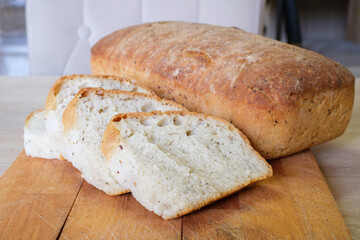 Sliced loaf of homemade bread on a wooden board