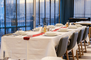 A long table is elegantly set for a formal dinner White linens and place settings create a sophisticated atmosphere