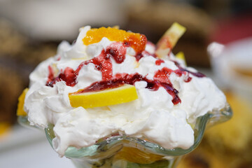 A delightful dessert featuring whipped cream fruit slices and a berry topping