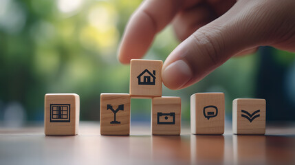 hand interacts with wooden blocks featuring financial and real estate symbols, representing investment concepts