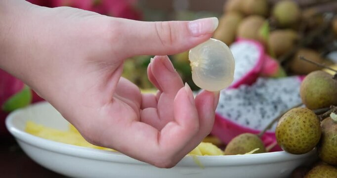 Hand holding fruit peeled lychee fruit. High quality FullHD footage