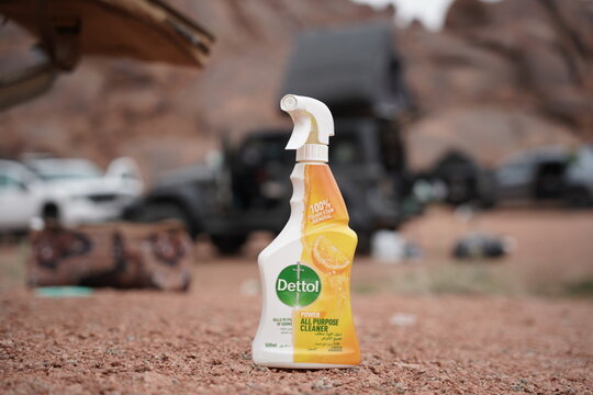A Dettol All-Purpose Cleaner bottle set in a rugged desert campsite. Off-road vehicles, camping gear, and rocky terrain highlight the balance of hygiene and adventure in outdoor exploration.