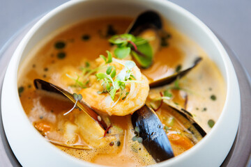 Shrimp Bisque with Seafood. King prawn, blue mussels, cod, whipped cream. Delicious traditional food closeup served for lunch in modern gourmet cuisine restaurant