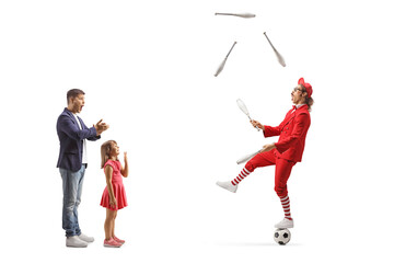 Father and daughter watching a man juggling