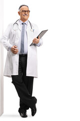 Mature male doctor leaning on a wall