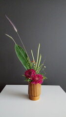 Fresh aster flower table arrangement in a ceramic vase as home decoration with foliage