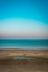 Fototapeta premium Serene beach with calm sea and clear blue sky