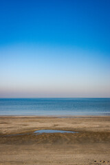 Serene beach with calm sea and clear blue sky
