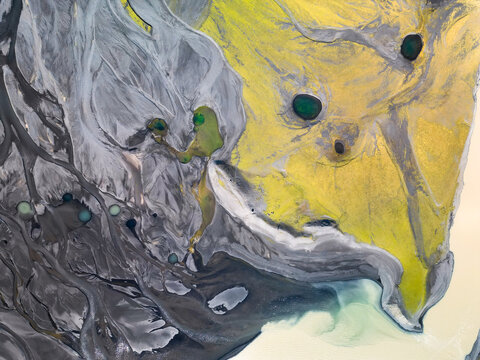 Green ponds in yellow moss and gray sand