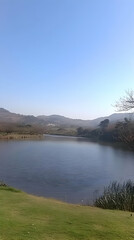 Serene lake, hills, clear sky, calm. Nature backdrop