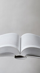 A close-up shot of an open book viewed from above, its pages blank, set against white background